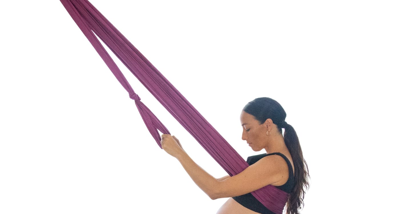 A pregnant person using The Birth Sling